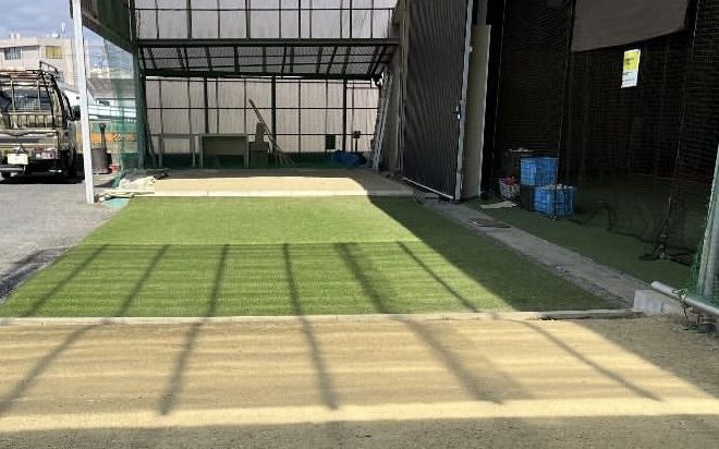 屋根のある練習スペースと人工芝のレーン